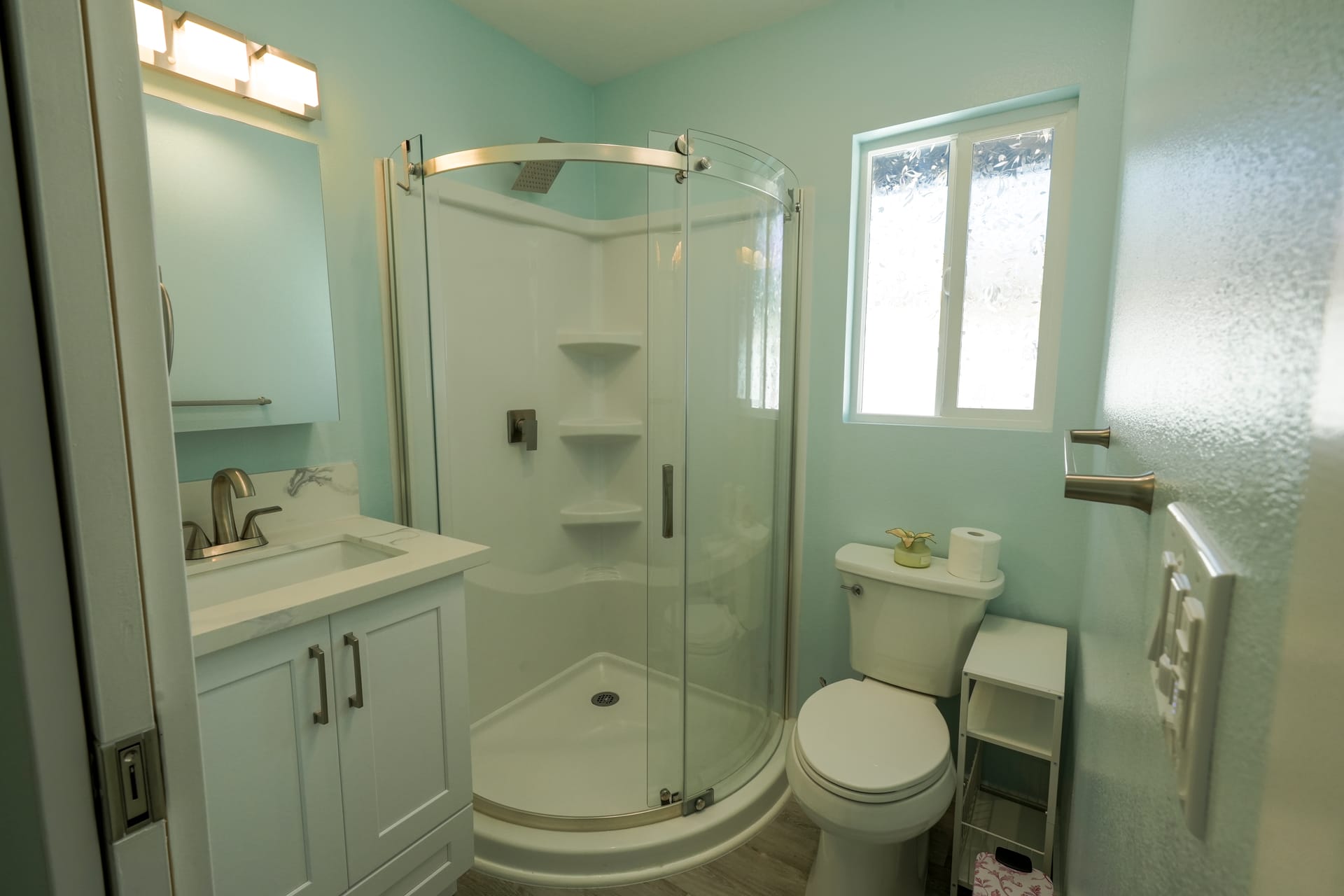 Bathroom vanity and glass shower in a bright finished room