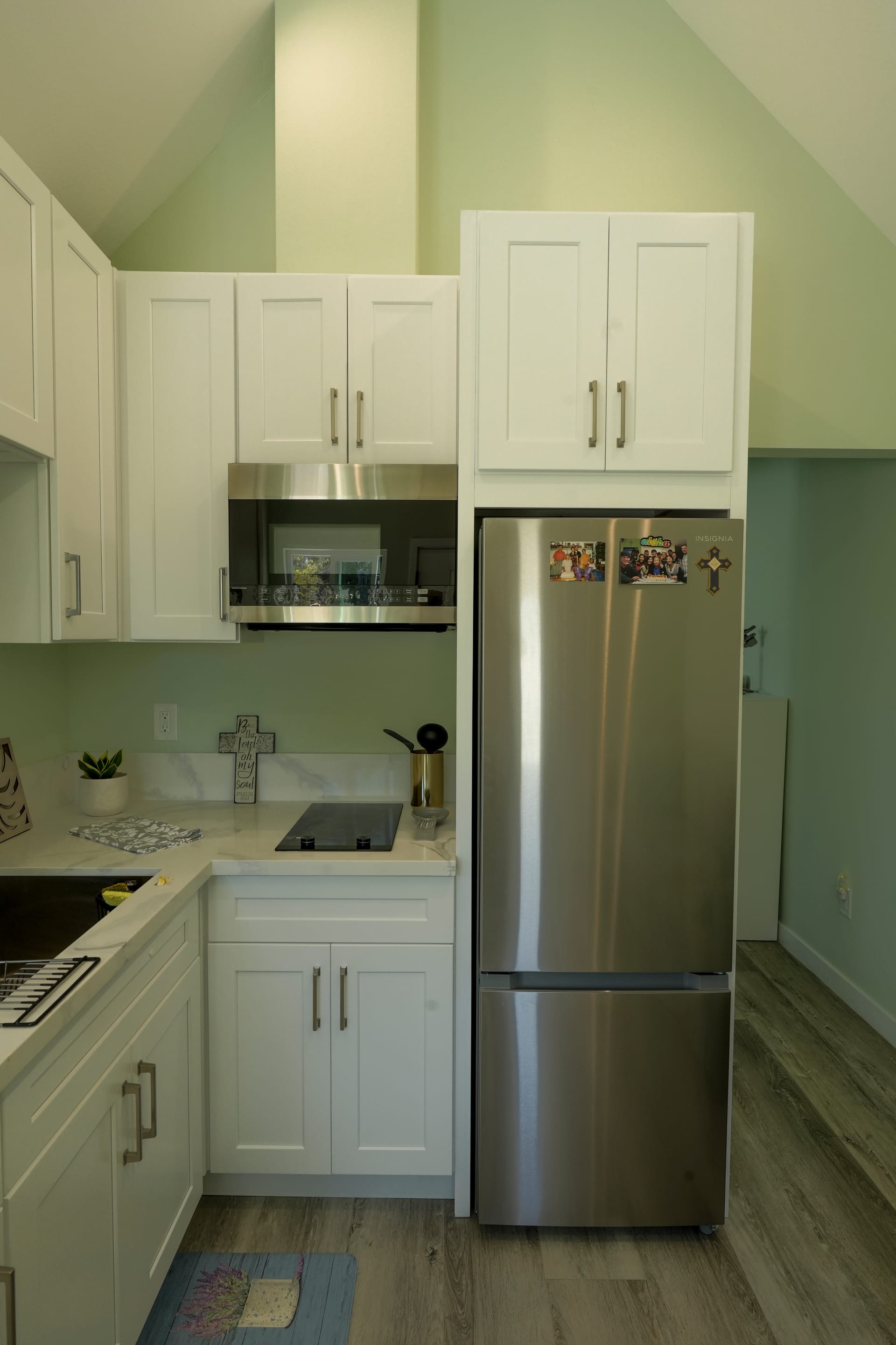 white kitchen cabinets, stainless refrigerator, sink, and microwave
