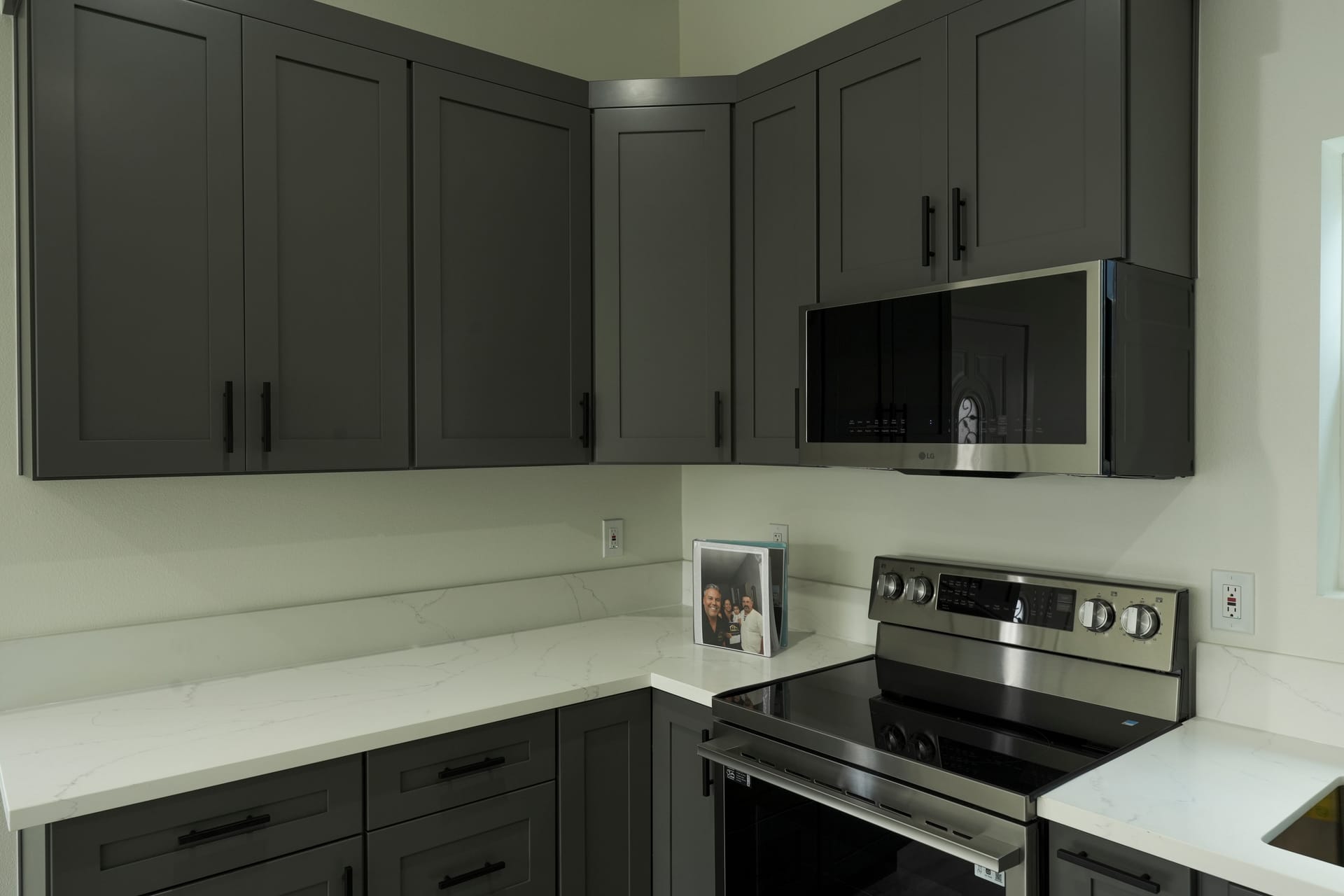 Kitchen corner with gray cabinets and white counters