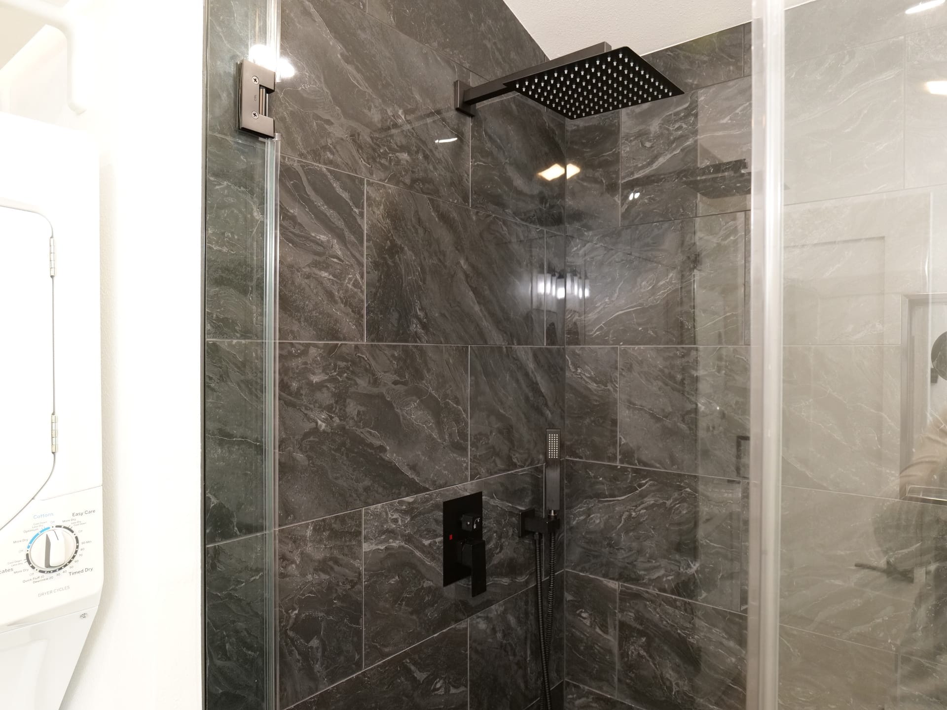Dark stone shower with glass enclosure