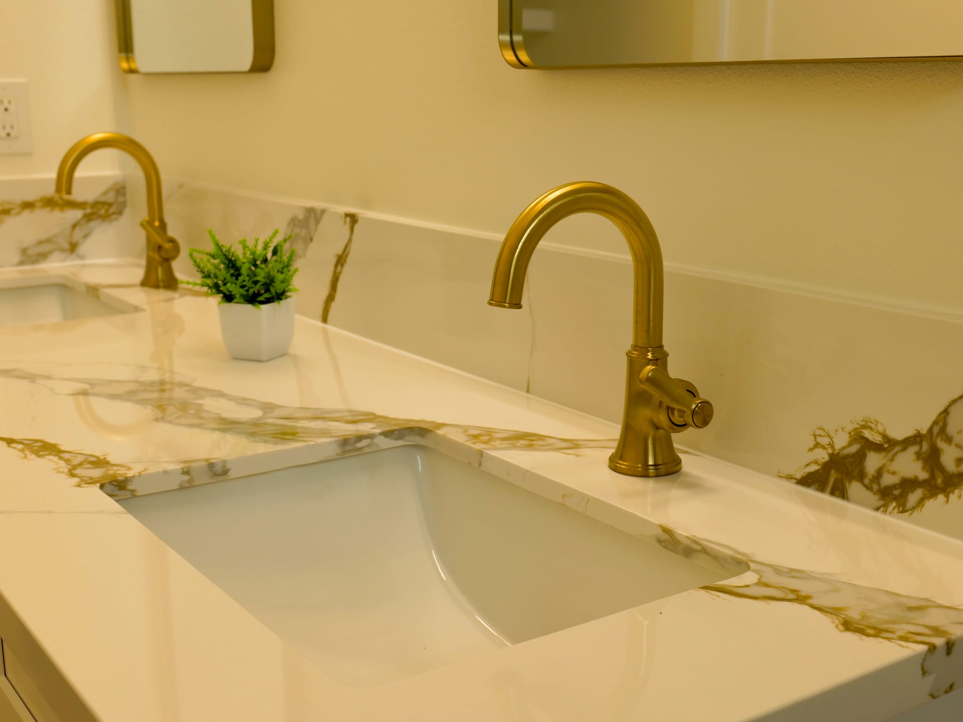 White bathroom sink with a gold-toned faucet