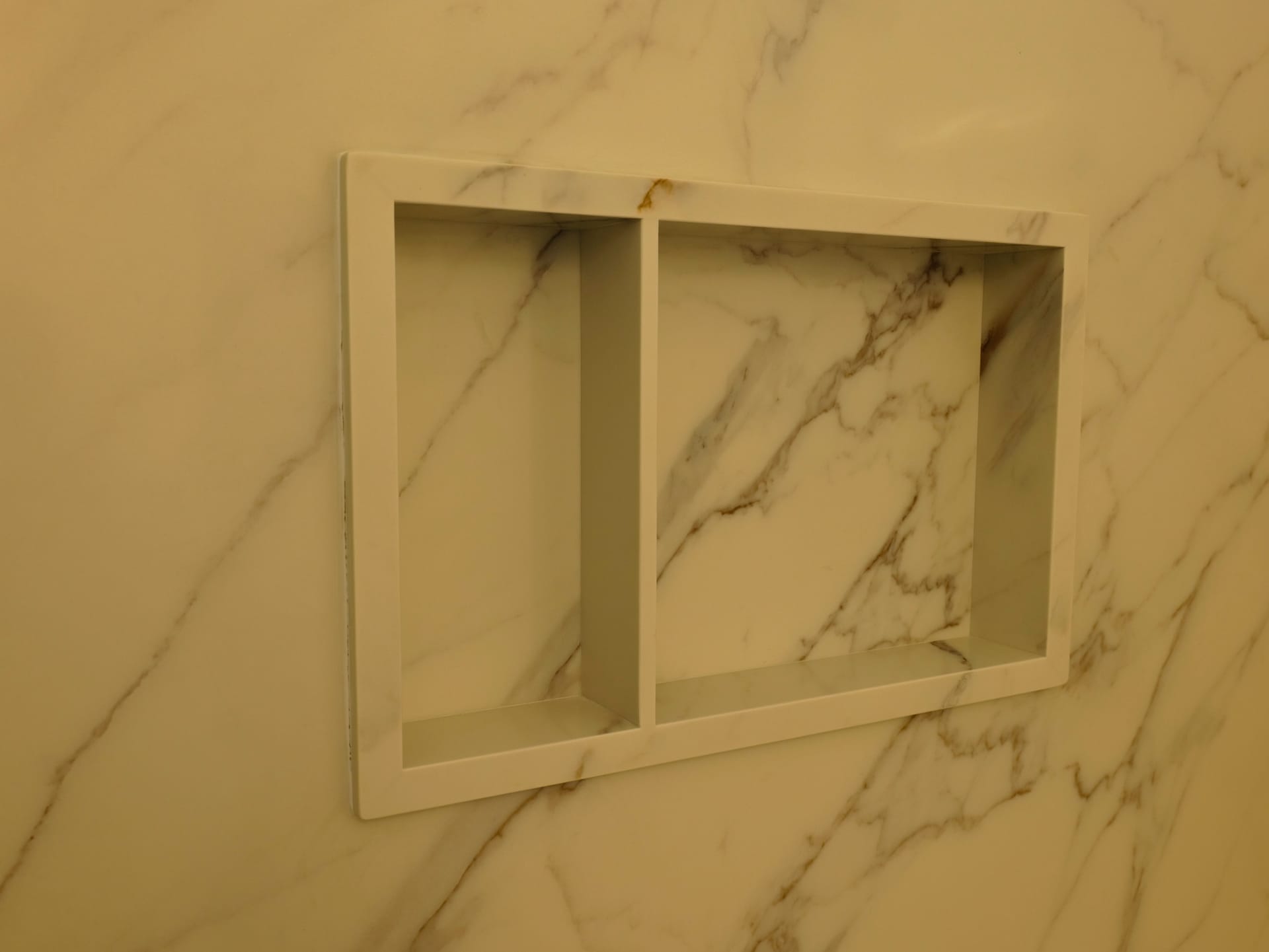 Marble-pattern shower walls and built-in niche