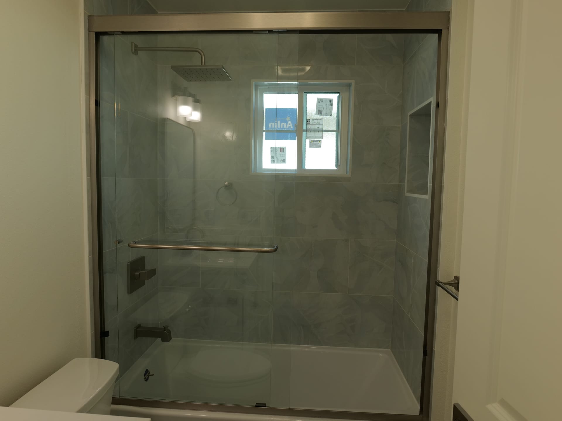 Glass shower enclosure with contrasting accent tile